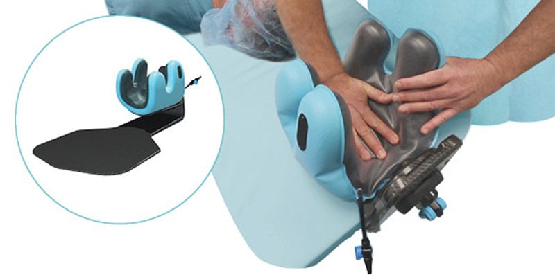 Surgical arm positioner supporting a patient's arm, with an inset view of the device.